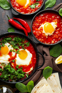 Three dishes of shakshuka with eggs, herbs, and toppings
