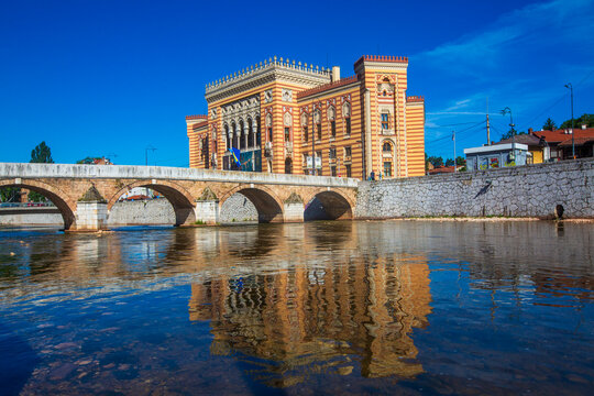 Scenic view of historical Vijecnica National Library building reflecting in Miljacka River near Secercija Bridge in Sarajevo - Bosnia and Herzegovina