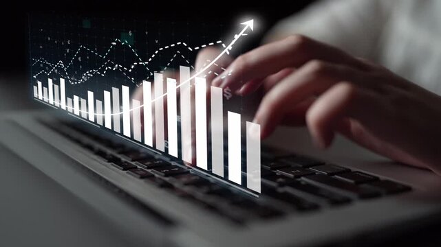 Close-up of hands typing on a laptop keyboard with a digital graph overlay, representing business growth and data analysis in a modern and professional environment. Copula