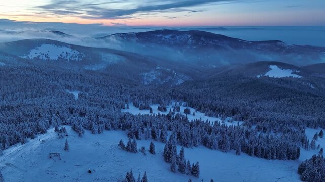 Aerial backward flight after sunset showing colorful twilight horizon over Beskid Zywiecki