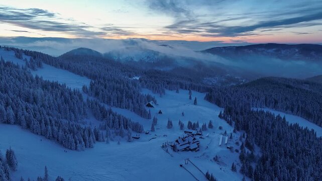 Aerial pull back from Hala Miziowa shelter during blue hour with rolling mountain mist