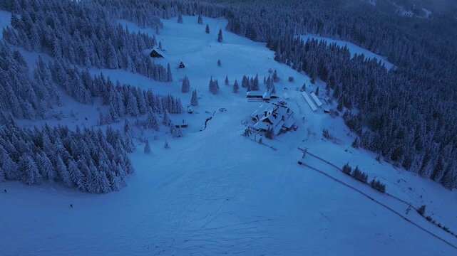 Top down aerial panning of Hala Miziowa mountain chalet in winter blue hour