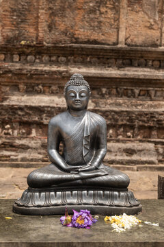 buddha statue in temple with flower offerings in Asia