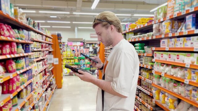 Young man shopping in supermarket, reading product information	