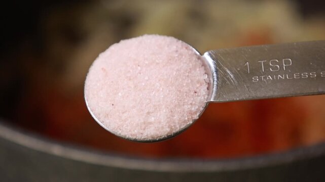 Close-up of preparing an aromatic food base by saut&eacute;ing diced onions with a rich blend of spices in a hot pot