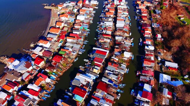 Narrow waterways flanked by dense residential huts. Top-down drone view of colorful boat houses, Burgas, Bulgaria