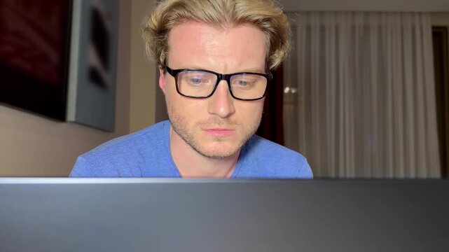 Young man working on computer at home,works remotely at a computer at home.