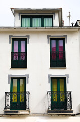 Obraz premium Whitewashed facade with balconies with colorful curtains in Tapia de Casariego town, Asturias