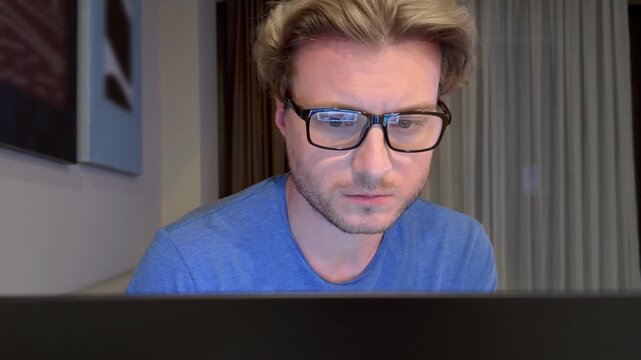 Young man working on computer at home,works remotely at a computer at home.