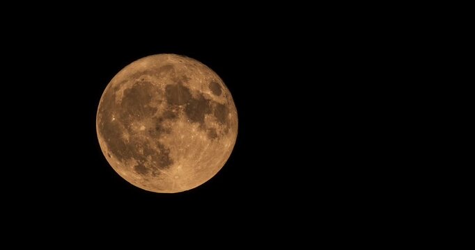 Super sharp close up view of the glowing full moon surface during nighttime astronomical timelapse.