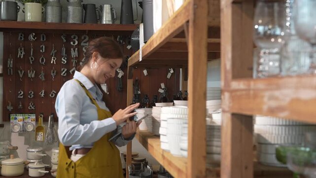 Employee organizes kitchenware in a store in daylight