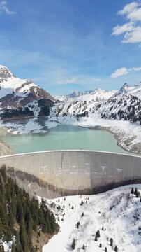 Vertical Aerial Flyby Hydroelectric Dam and Reservoir in Snowy Alps