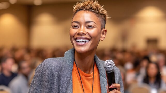 Confident woman speaking into microphone at conference with audience in background