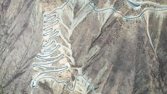 Drone view of winding road on Muma mountains in Jinchuan country, Aba Tibetan and Qiang Autonomous Prefecture, Sichuan, China. 4k real time top down footage, travel concept.