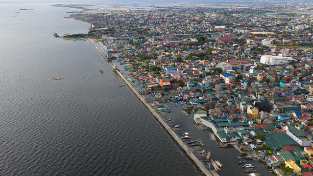 Aerial view of the densely populated coastal district with colorful rooftops and small boats docked along the waterfront in Manila, Metro Manila, Philippines.