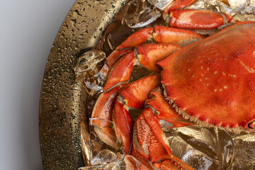 Fresh oyster on half shell served on crushed ice with lime. Tight macro of open bivalve showing pale flesh and ruffled edges on gold tray. © Vadim