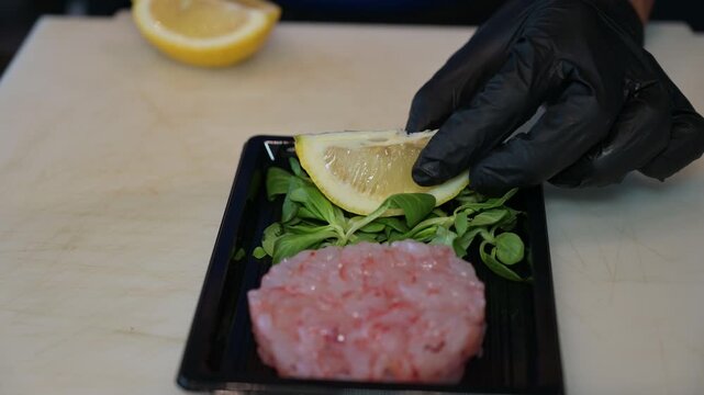 Limone tagliato a fette per la preparazione di un piatto di crudo di mare