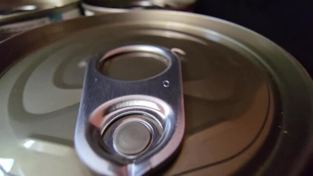 Macro shot of a metal tin can lid with an easy-open ring pull, highlighting food packaging and emergency storage.