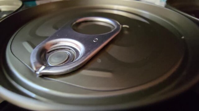 Macro shot of a metal tin can lid with an easy-open ring pull, highlighting food packaging and emergency storage.