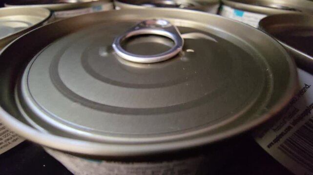 Macro shot of a metal tin can lid with an easy-open ring pull, highlighting food packaging and emergency storage.