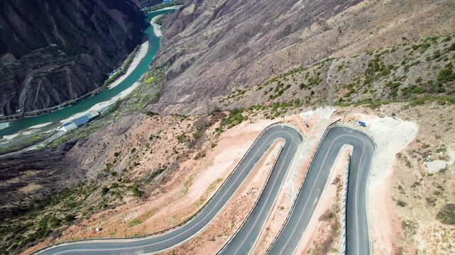 Drone view of winding road on Muma mountains in Jinchuan country, Aba Tibetan and Qiang Autonomous Prefecture, Sichuan, China. 4k real time top down footage, travel concept.
