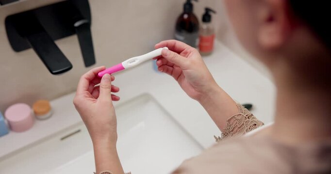 Health, pregnancy test and hands of woman in bathroom at house for good news, fertility or IVF success. Morning, pregnant and person with positive result for future planning with wellness in home.