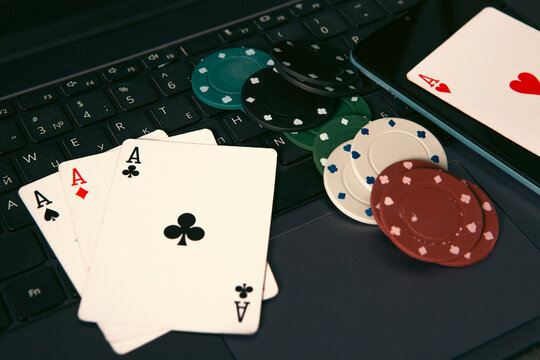 Poker chips and cards on the laptop keyboard. Online casino concept