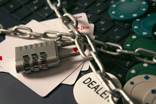 Laptop with a lock and poker chips. Online gambling concept.