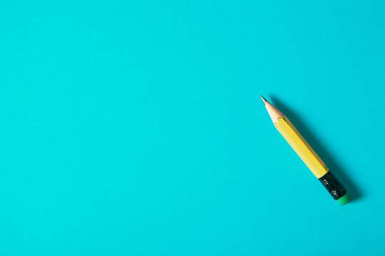 Yellow pencil on a blue background. Back to school. Copy space.