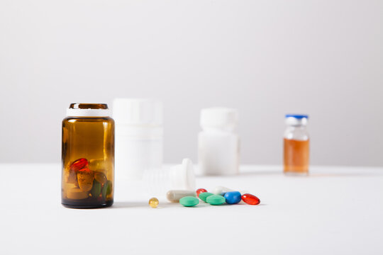 Colorful pills and capsules on white background. Focus on foreground.