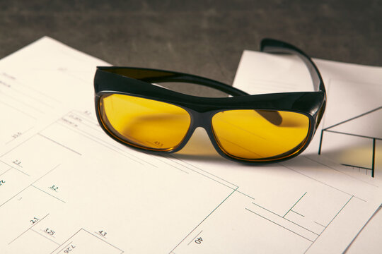 Sunglasses on the background of the architectural plan. Selective focus.
