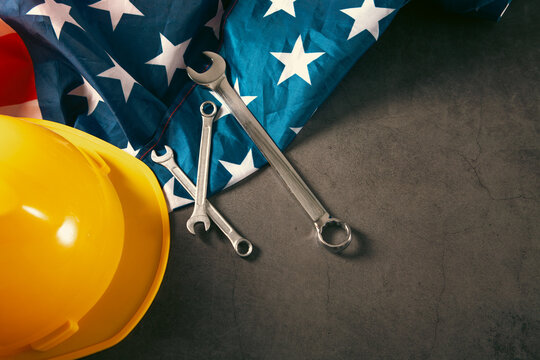 Helmet and tools on American flag background. Labor day concept.