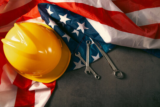 Helmet and tools on American flag background. Labor day concept.