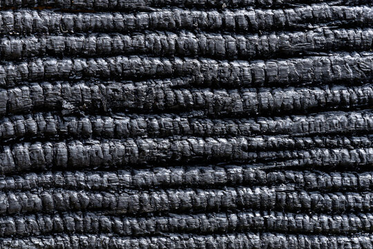 Rounded parallel rows of heavily burnt black wood texture