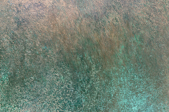 Brushed copper surface texture with green verdigris spots background