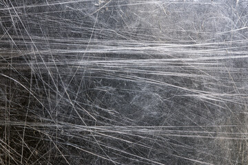 Fototapeta premium Close up of scratched black steel sheet with silver lines