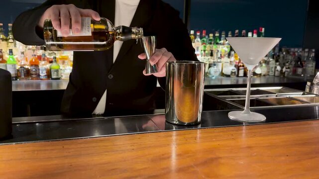 Professional Japanese Bartender Pouring Liquor into a Jigger at a Bar