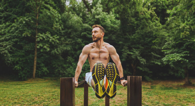 Athletic Man Performing L Sit Exercise Outdoors