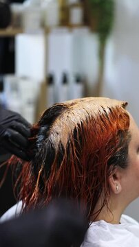 Gros plan zoom application et shampooing de couleur coloration au salon de coiffure chez la coiffeuse coiffeur