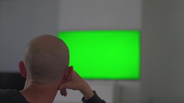 Man reaching toward green screen display