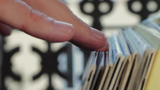 Hand Sorting CDs on a Shelf Organizing Music Collection and Media Archive