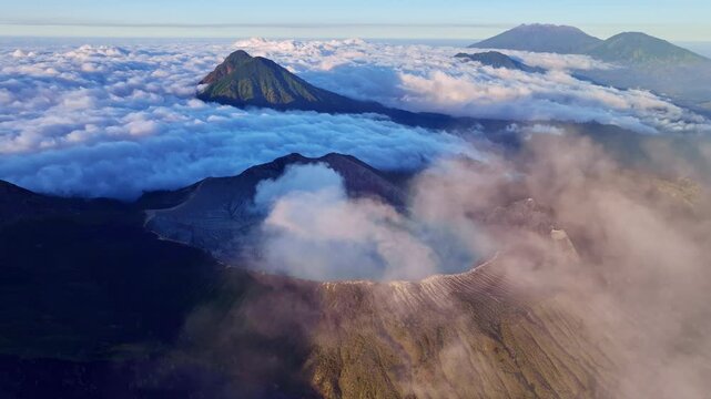 Aerial view of fog at Kawah Ijen volcano with turquoise sulfur water lake at sunrise.Amazing nature landscape view at East Java,Indonesia.Beautiful light Natural landscape background