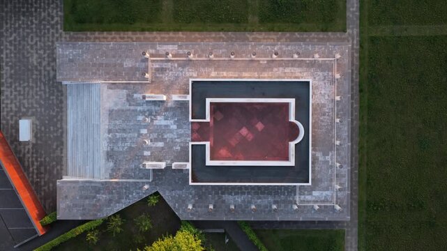 Aerial perspective of a Roman temple replica in Tongeren, showcasing its symmetrical architecture amidst surrounding greenery. Suitable for historical documentaries or travel content.
