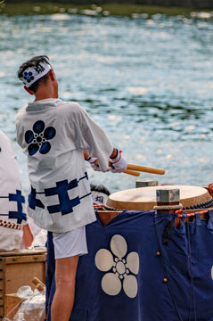 OSAKA - JULY 25, 2025: A man performs on traditional Japanese taiko drums during the Tenjin Matsuri festival procession on the river.