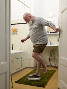 Santa stepping on a weighing machine in the bathroom