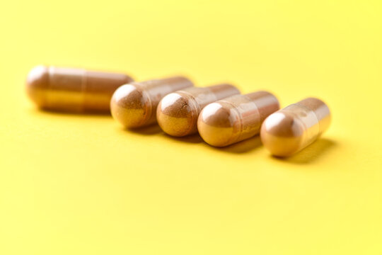 Ashwagandha (Withania somnifera) capsules. Concept for a healthy dietary supplementation. Bright paper background. Soft focus. Close up. Copy space