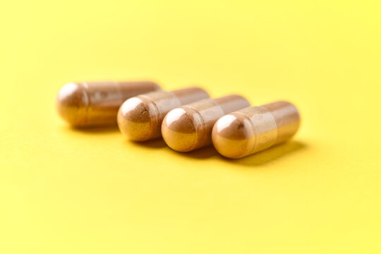 Ashwagandha (Withania somnifera) capsules. Concept for a healthy dietary supplementation. Bright paper background. Soft focus. Close up. Copy space
