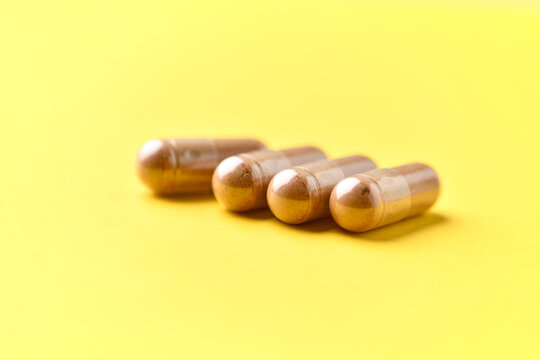 Ashwagandha (Withania somnifera) capsules. Concept for a healthy dietary supplementation. Bright paper background. Soft focus. Close up. Copy space