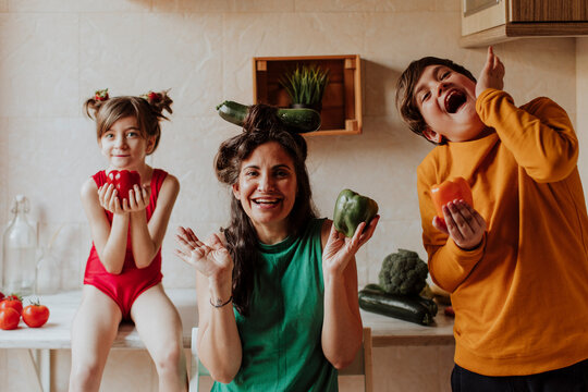 Mother and family having fun with vegetable in home kitchen