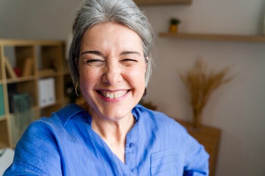 Happy woman taking a joyful selfie at home
